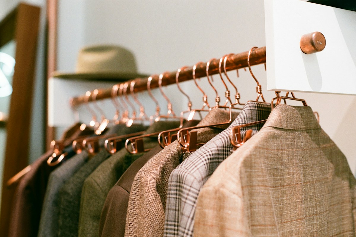 Neutral menswear pieces arranged on a clothing rack for a versatile wardrobe