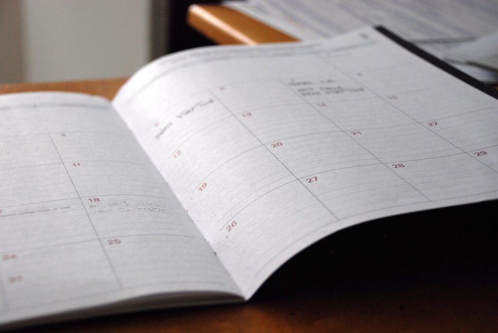 Man conducting a weekly review with notebook and calendar
