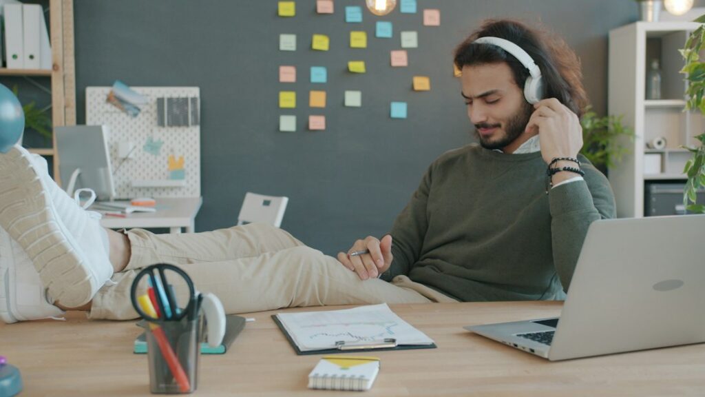 Man practicing a new language with headphones smartphone and notebook