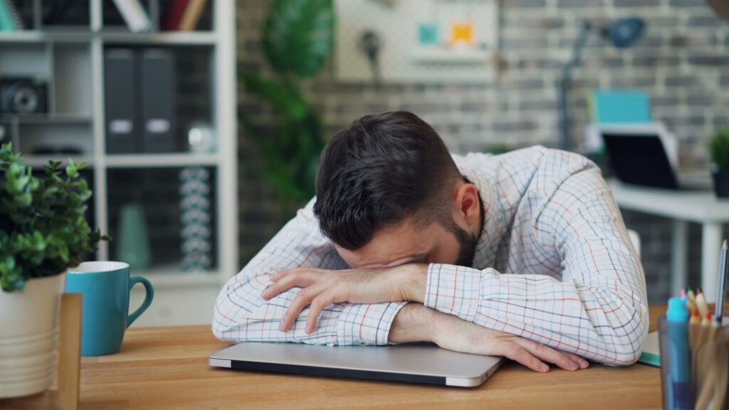 Mentally tired man facing too many choices at his desk