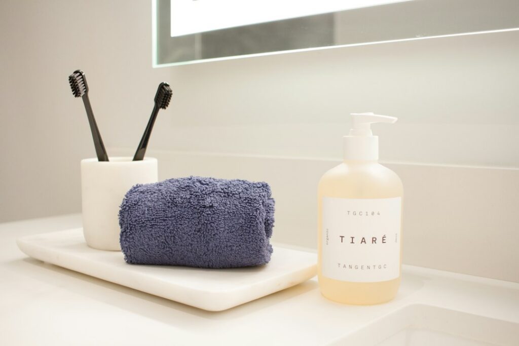 Oral care supplement bottle beside a toothbrush on a clean counter
