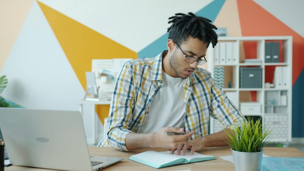 Man writing goals in a notebook at a desk