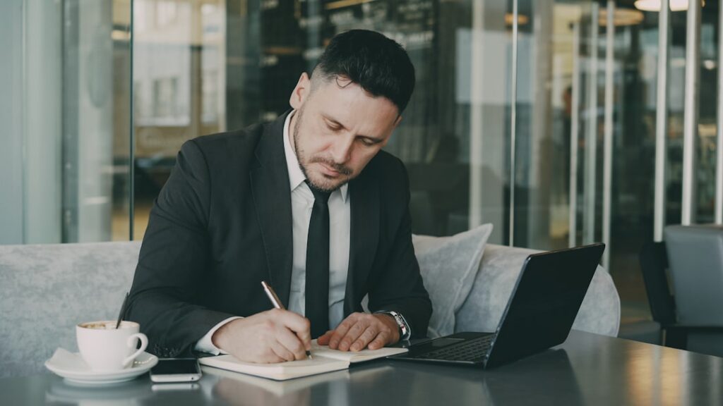 Businessman planning his day in a notebook at a professional desk