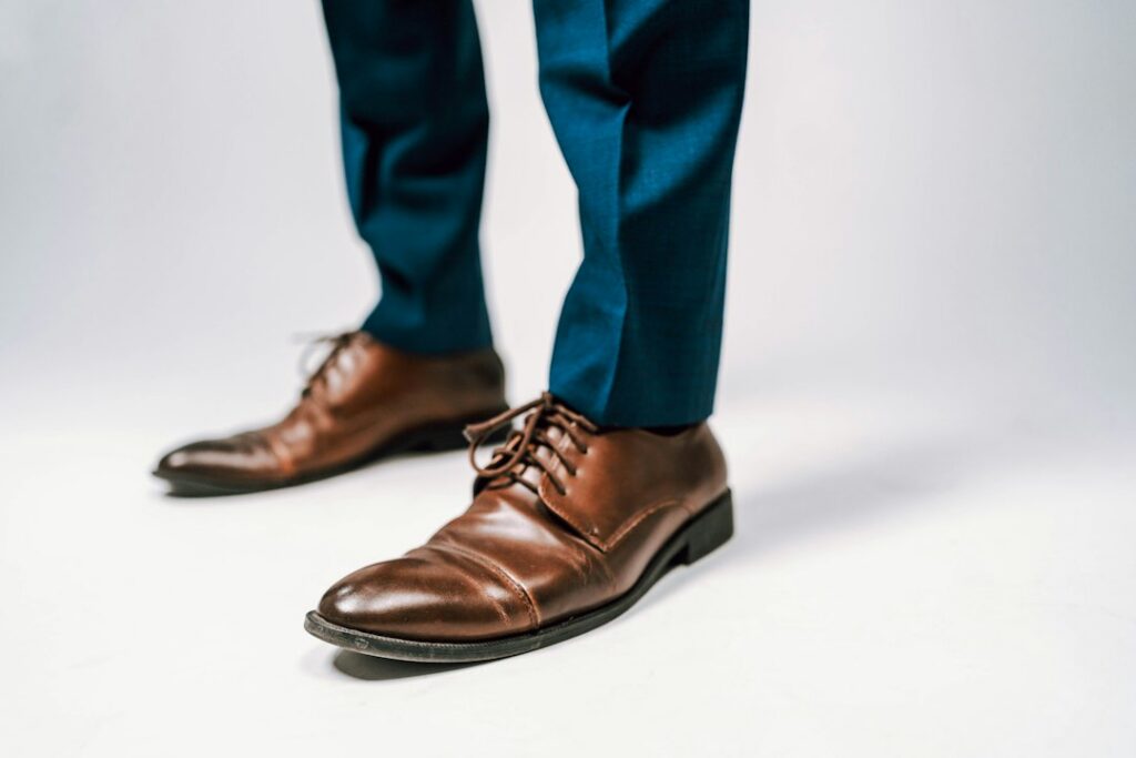 Tailored trousers showing the trouser break over dress shoes
