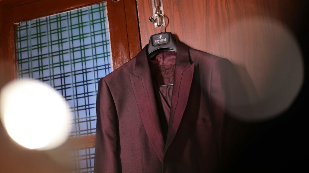 Several classic men's suits arranged in a wardrobe