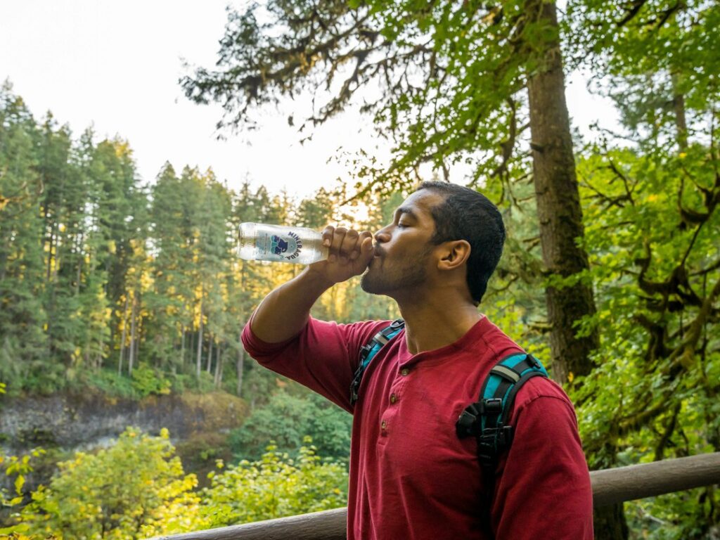 Man drinking water outdoors to stay hydrated