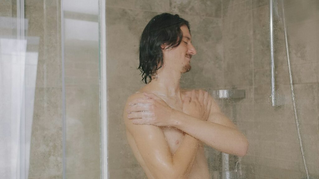 Man washing his hair with shampoo in the shower