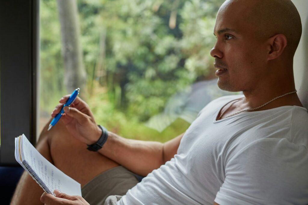Man reflecting on his progress in a notebook