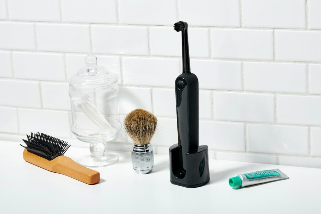 Electric razor being cleaned and maintained beside a sink