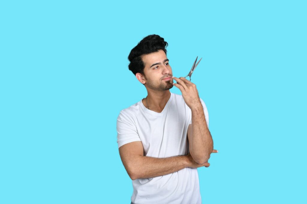 Man lightly grooming his eyebrows in front of a mirror