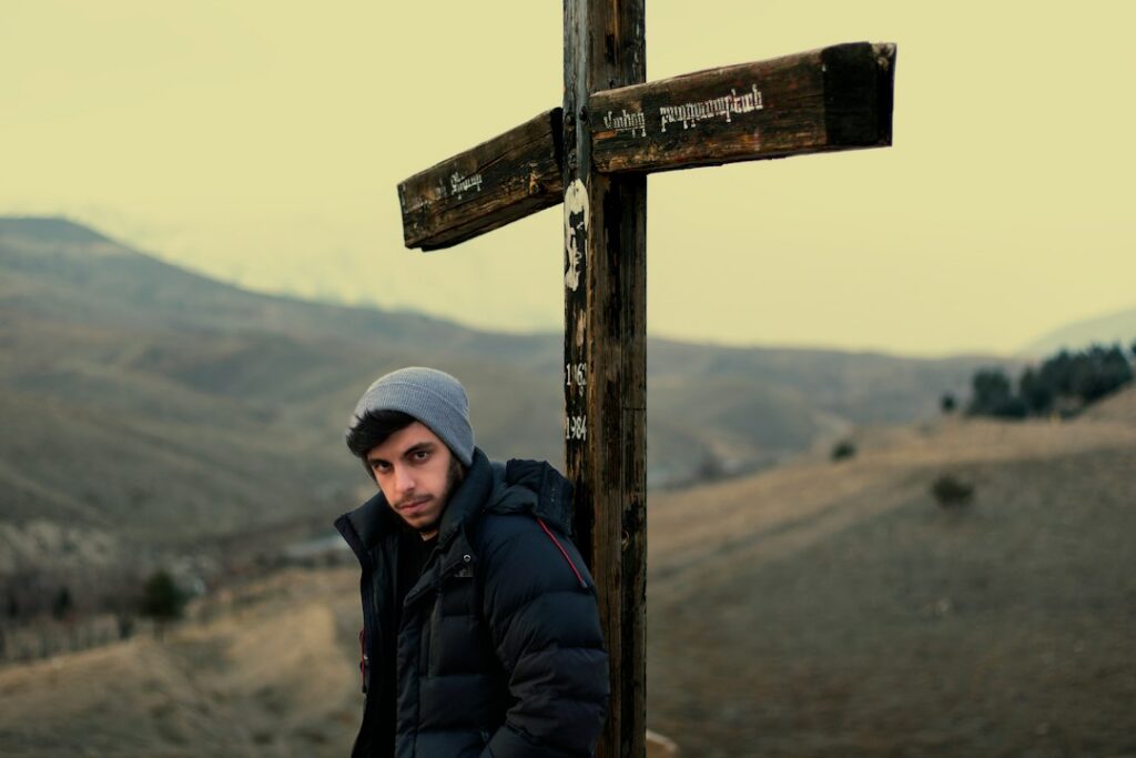 Man pausing at a trail junction while considering which direction to take