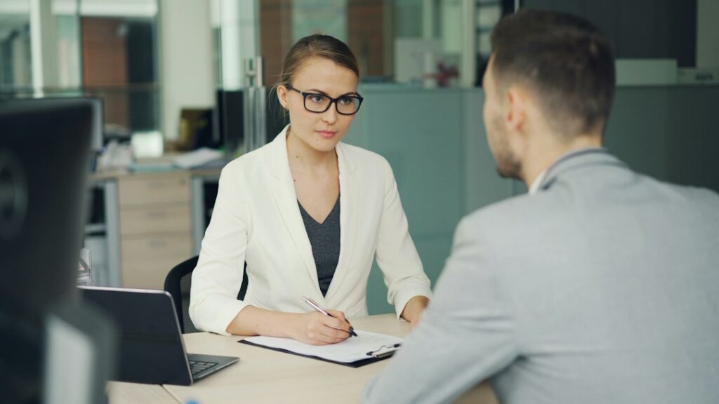 Job candidate speaking naturally with an interviewer in a modern office