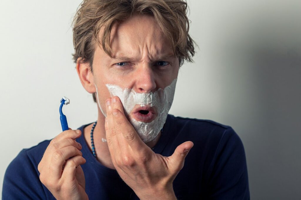 Man shaving carefully to avoid razor bumps and irritation