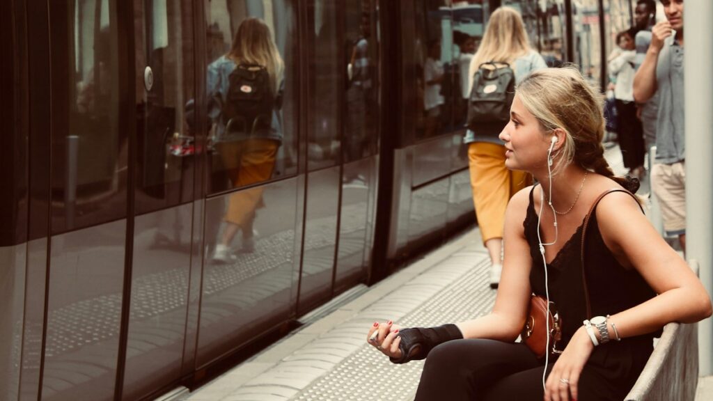 Commuter waiting by a train while using travel time for language learning