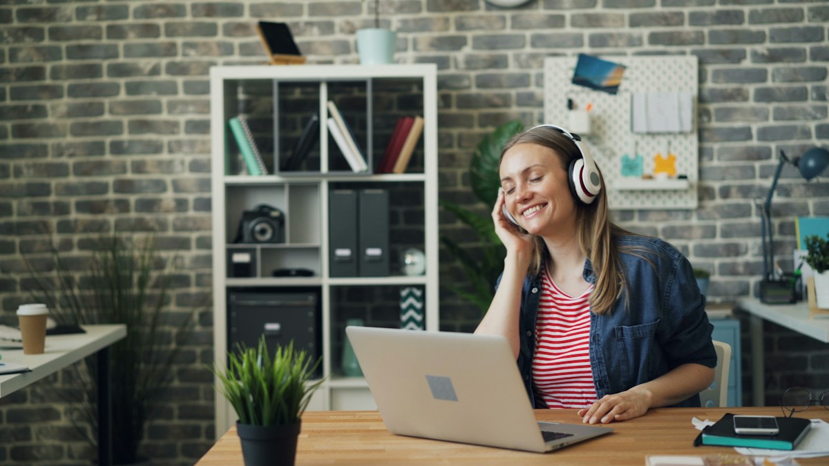 Adult using headphones at a desk during a language learning session