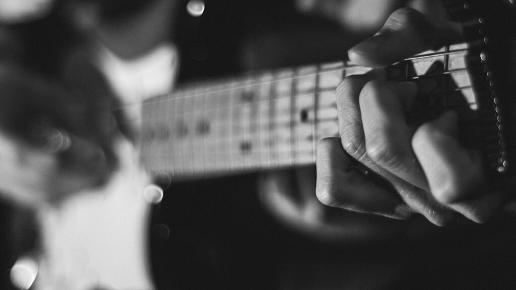 Close-up of guitar strings and fretboard during playing