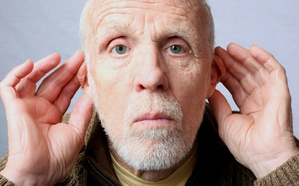 Man experiencing ear discomfort in a quiet room