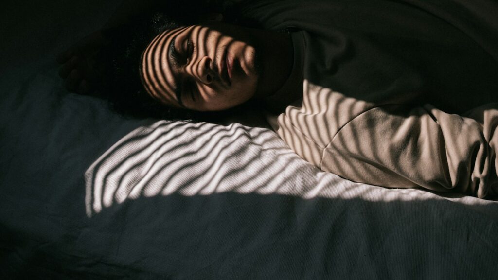 Man sleeping in bed for a review discussing melatonin and memory claims