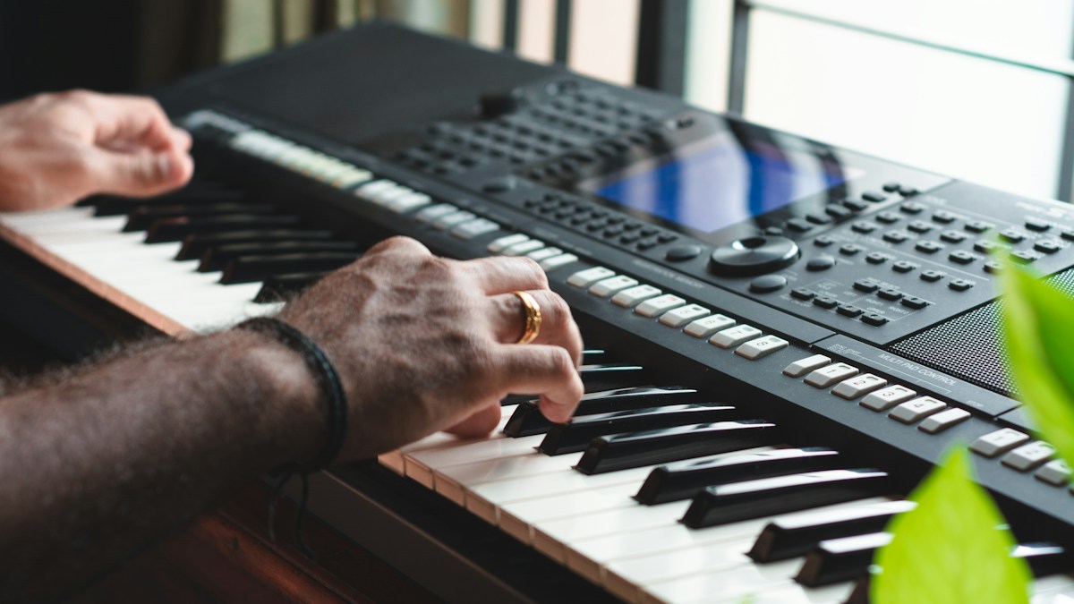 Adult learning piano independently at a keyboard