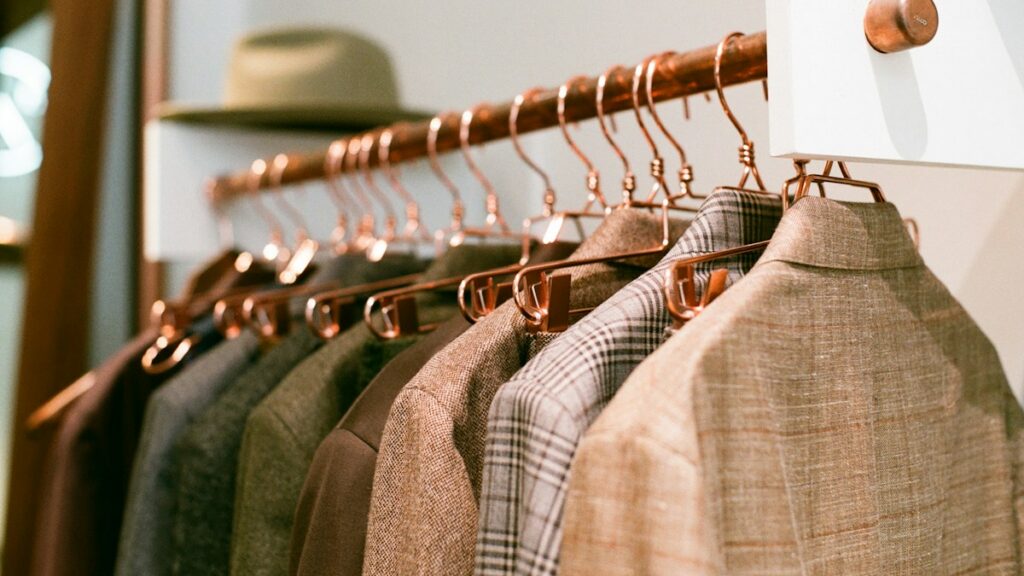 Men's suits hanging in a wardrobe for proper suit care
