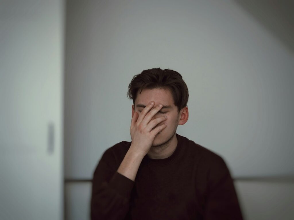 Man holding his ear while experiencing hearing discomfort