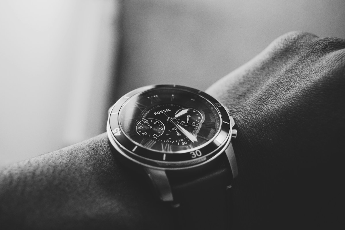 Close view of an analog wristwatch with a dark dial