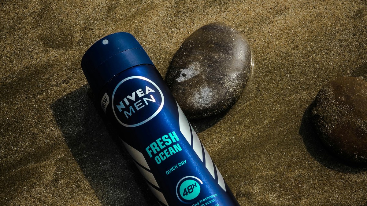 Men's antiperspirant spray beside a smooth stone