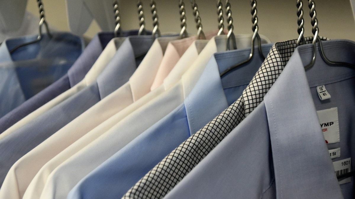 Dress shirts hanging together on a clothing rail