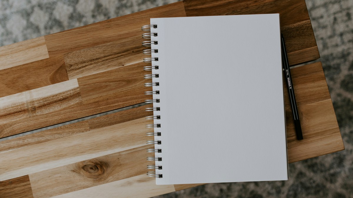 Open spiral notebook on a wooden desk