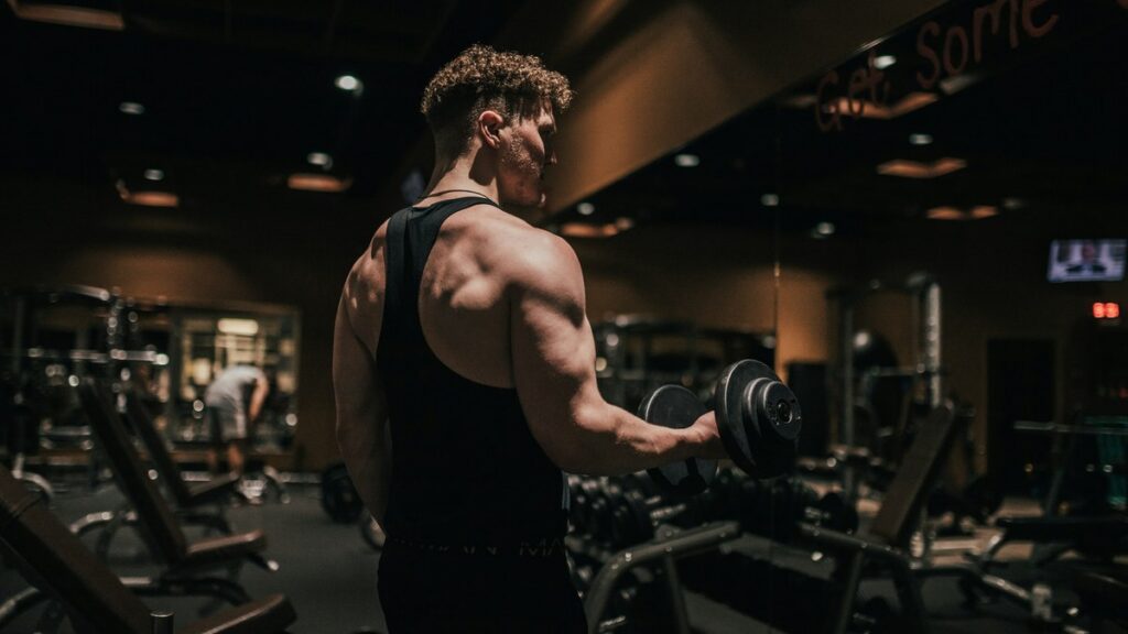 Man lifting a dumbbell in a gym