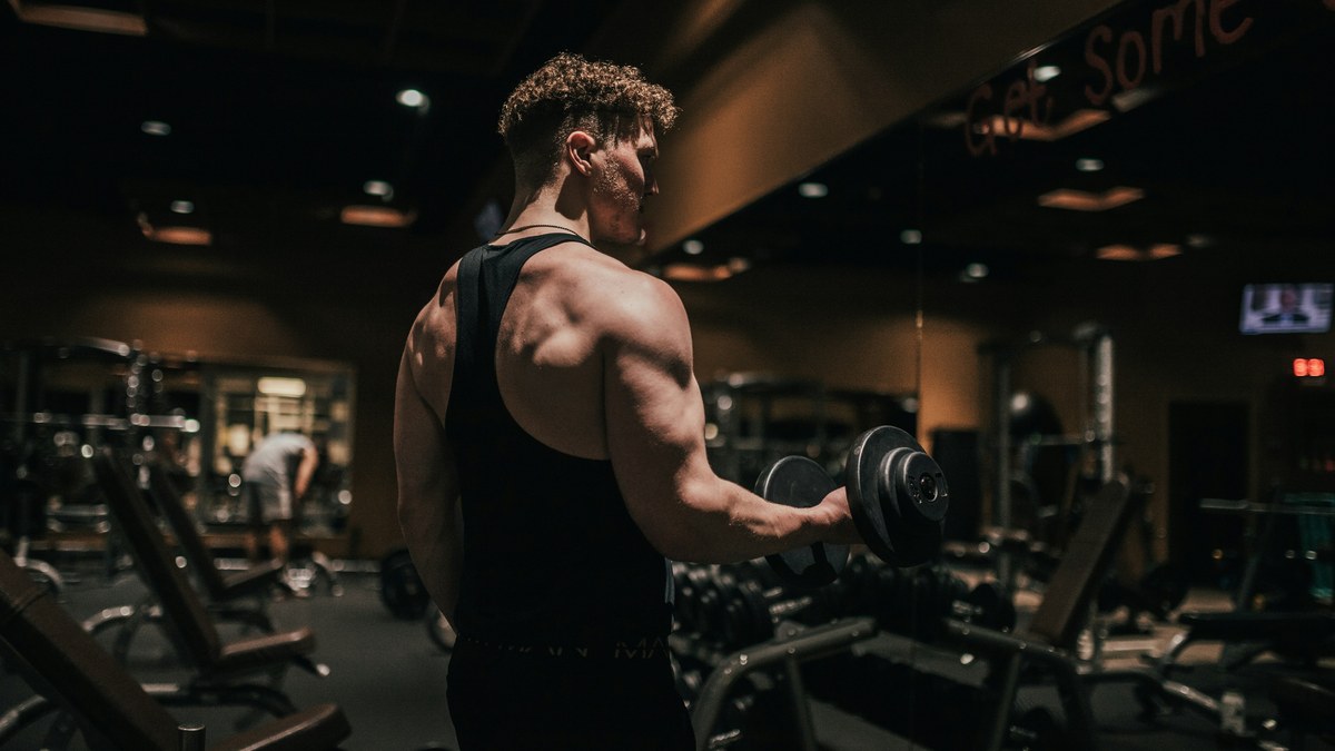 Man lifting a dumbbell in a gym