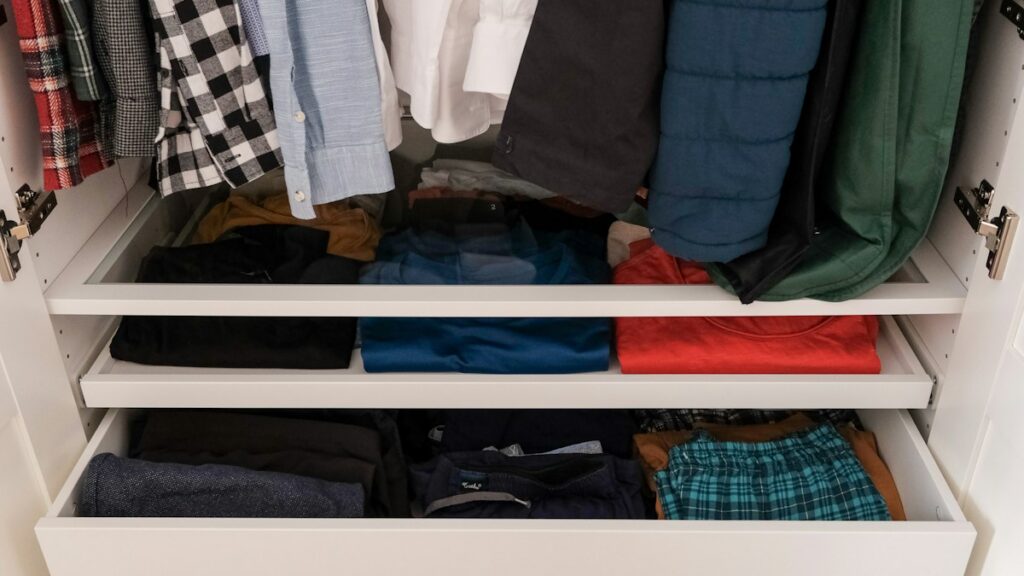 Organized wardrobe with shirts and folded clothing in drawers
