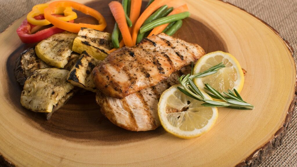 Cooked chicken with vegetables and lemon on a plate