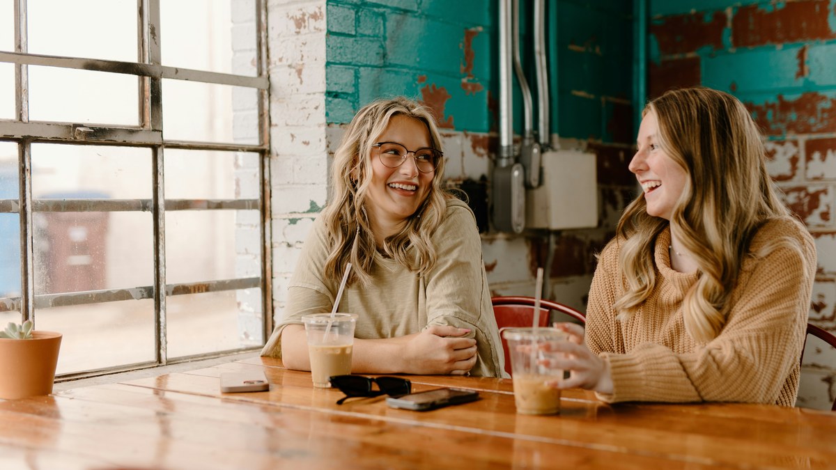 Two women talking at a cafe table