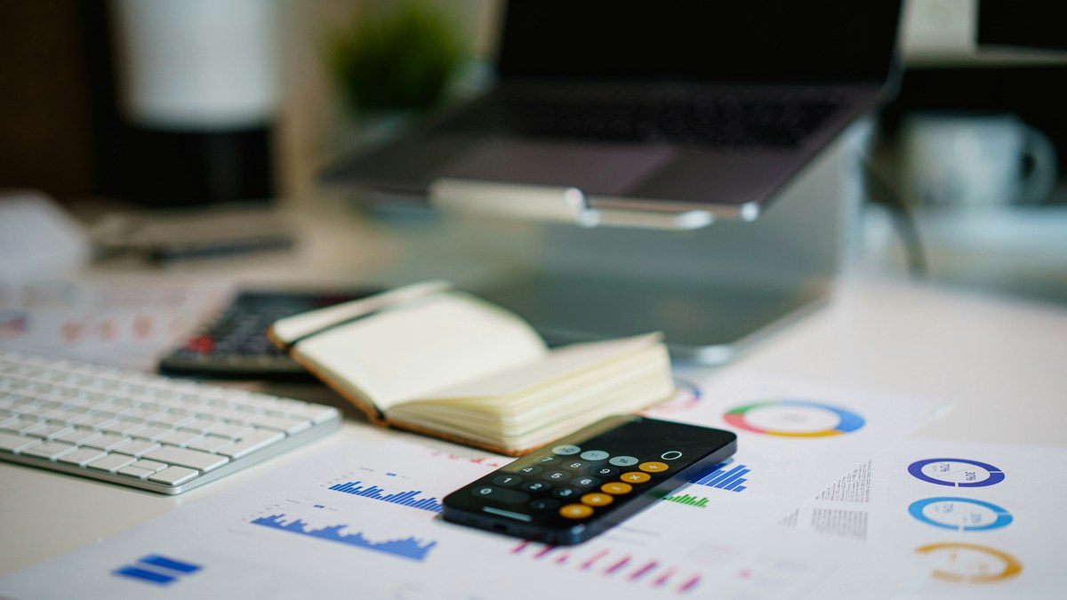 Computer, calculator and financial notes on a desk