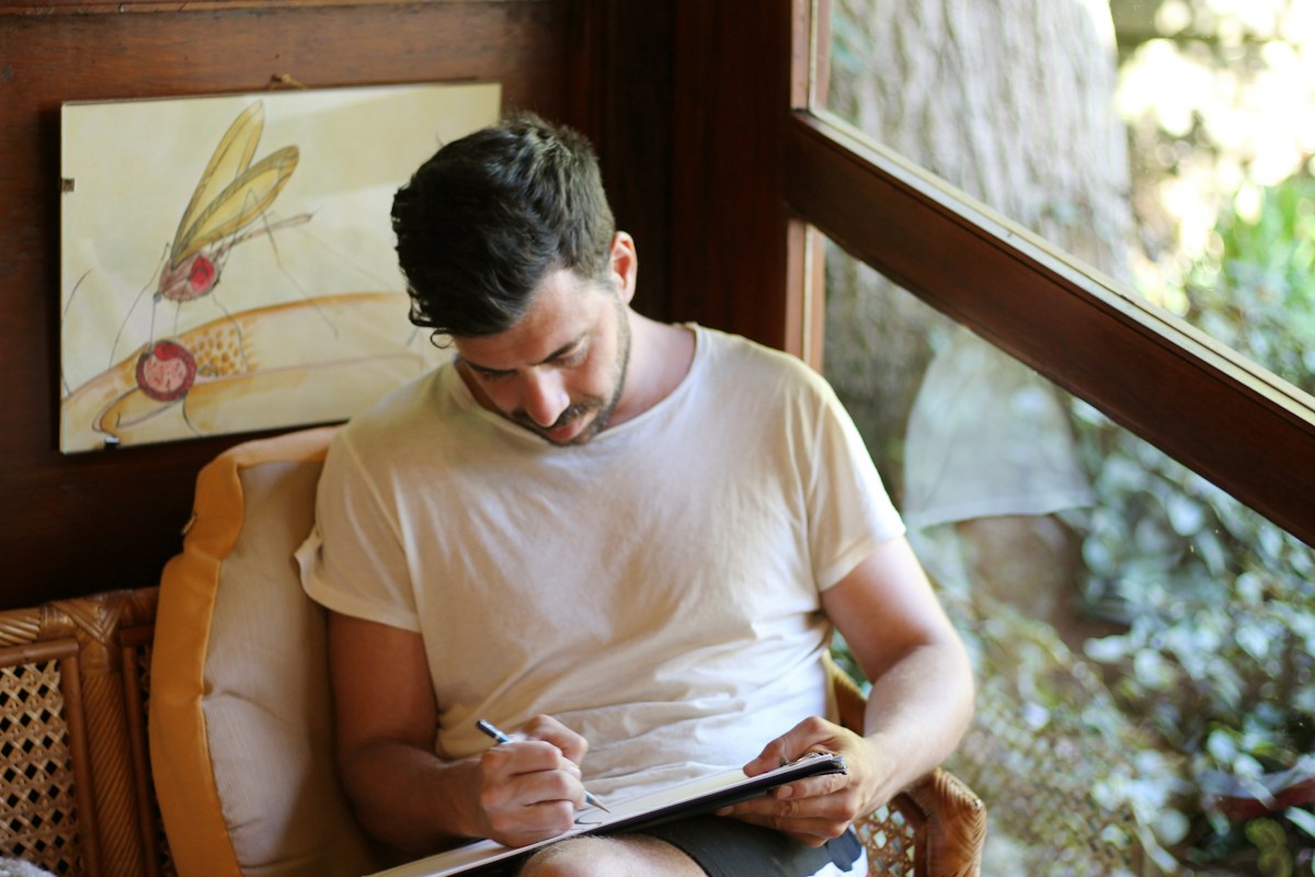 Man writing by hand during a reflective practice