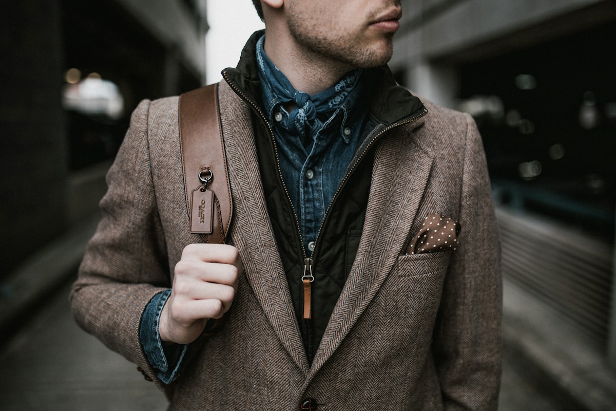Man wearing a textured brown jacket over a denim shirt