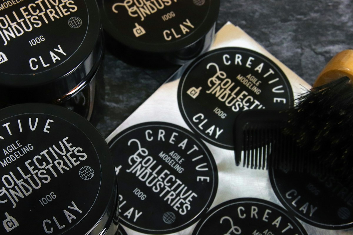 Hair styling product tins arranged beside a mirror