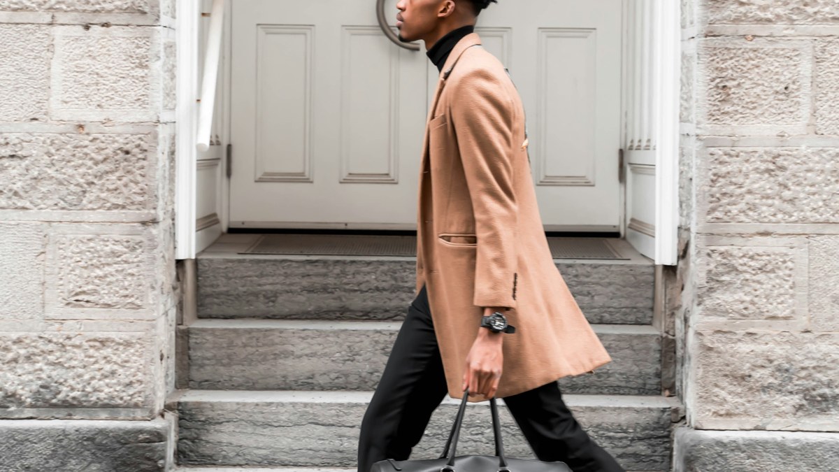 Man wearing a camel overcoat in a city