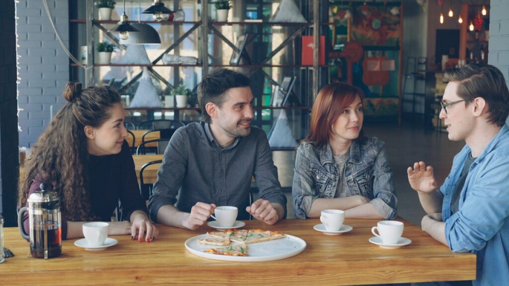 Friends talking and laughing together at a cafe