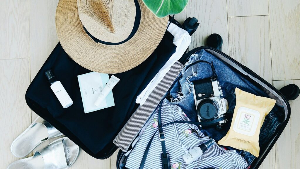 Open suitcase with travel clothes and accessories