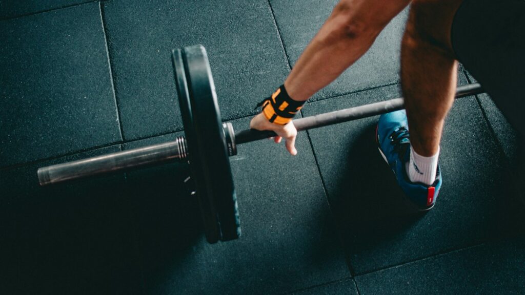 Close-up of a lifter gripping a barbell on a gym floor