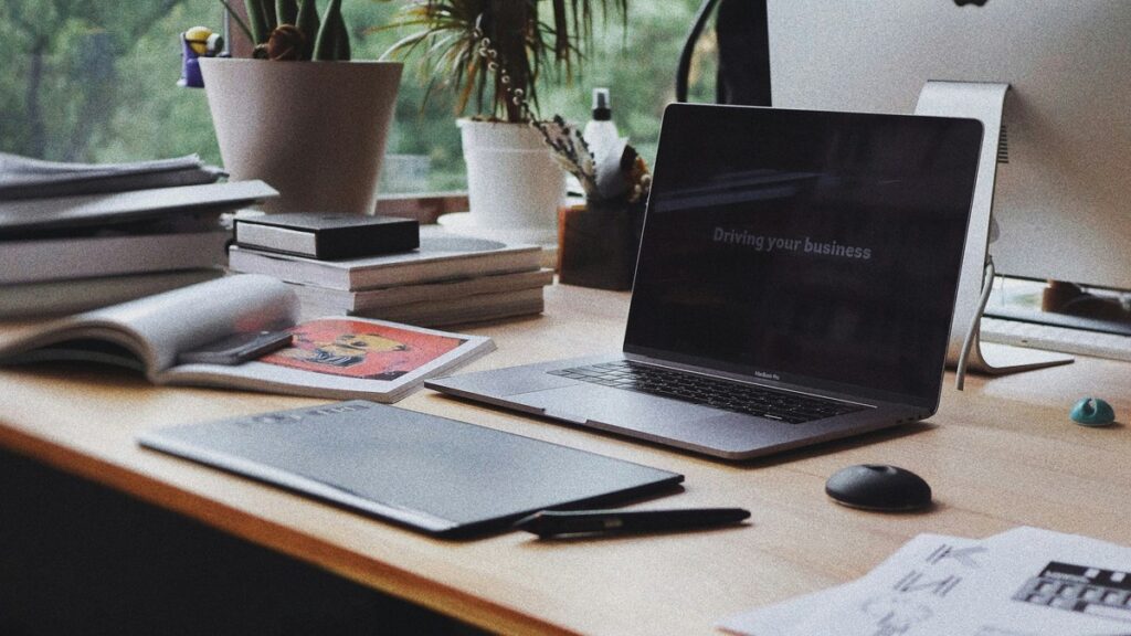 Laptop, notebooks and plants on a home desk