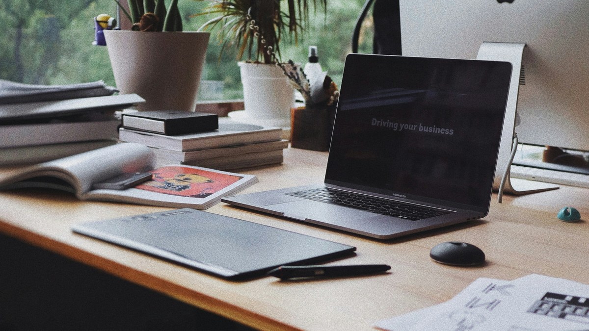 Laptop, notebooks and plants on a home desk