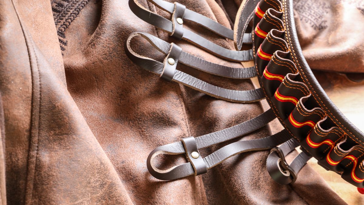 Brown leather belt laid on a surface showing strap width and stitching