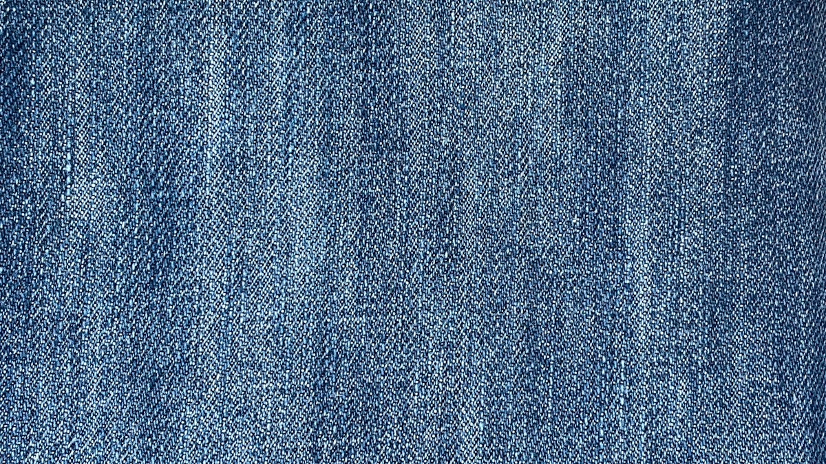 Close view of blue denim weave illustrating how denim color and texture change