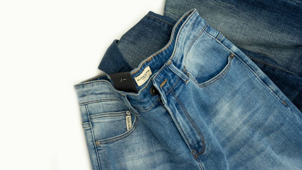 Blue denim jeans laid together, featured image for jeans washing and care