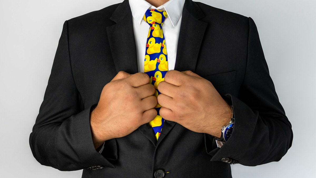 Close view of a blue necktie worn with a dark tailored suit