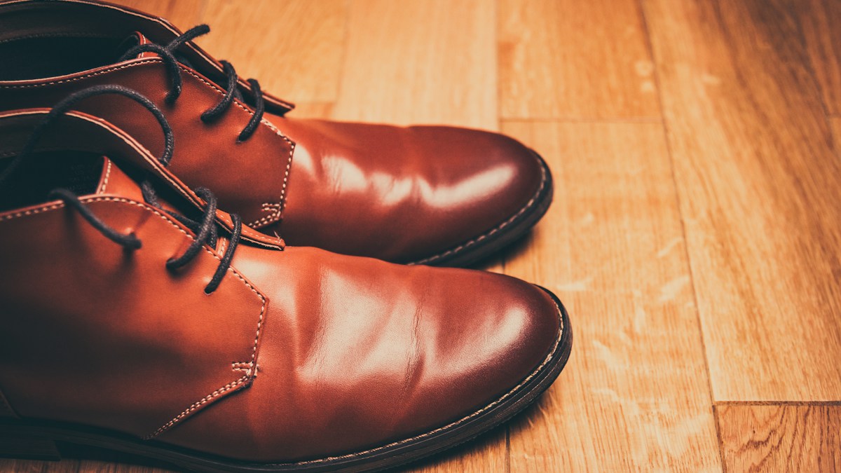 Brown leather boots resting on a wooden surface