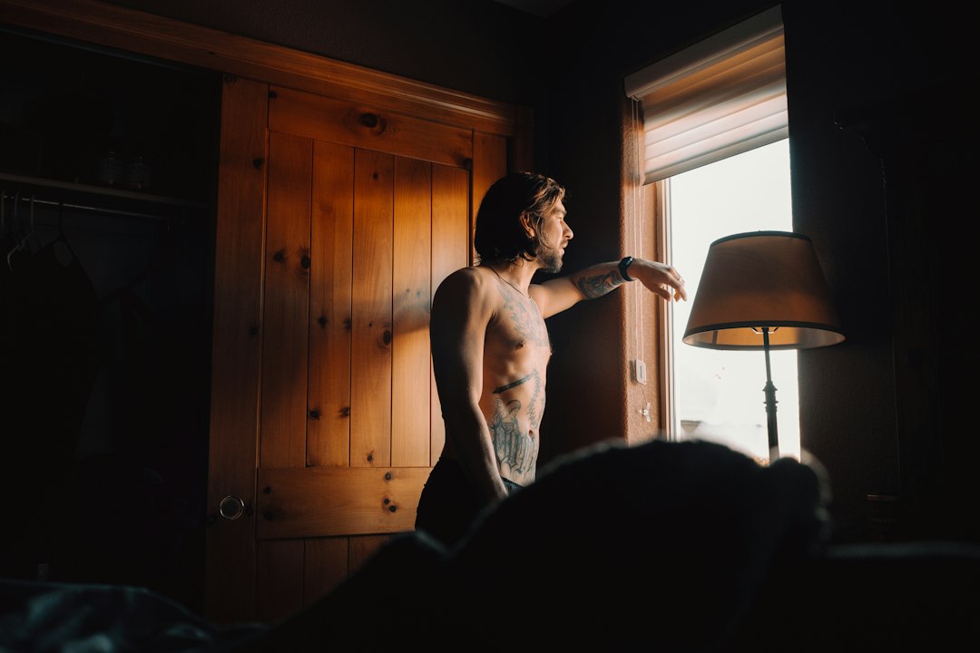 Man standing near a bright window in the morning